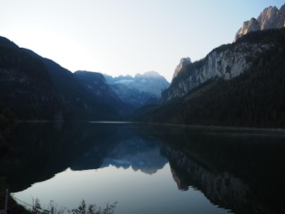 A serene mountain lake at sunrise with puzzle letters floating gently above the water.