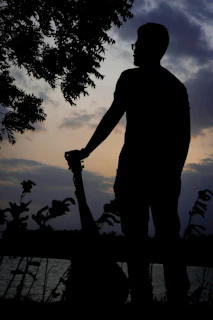 A serene portrait of a singer-songwriter with an acoustic guitar outdoors.