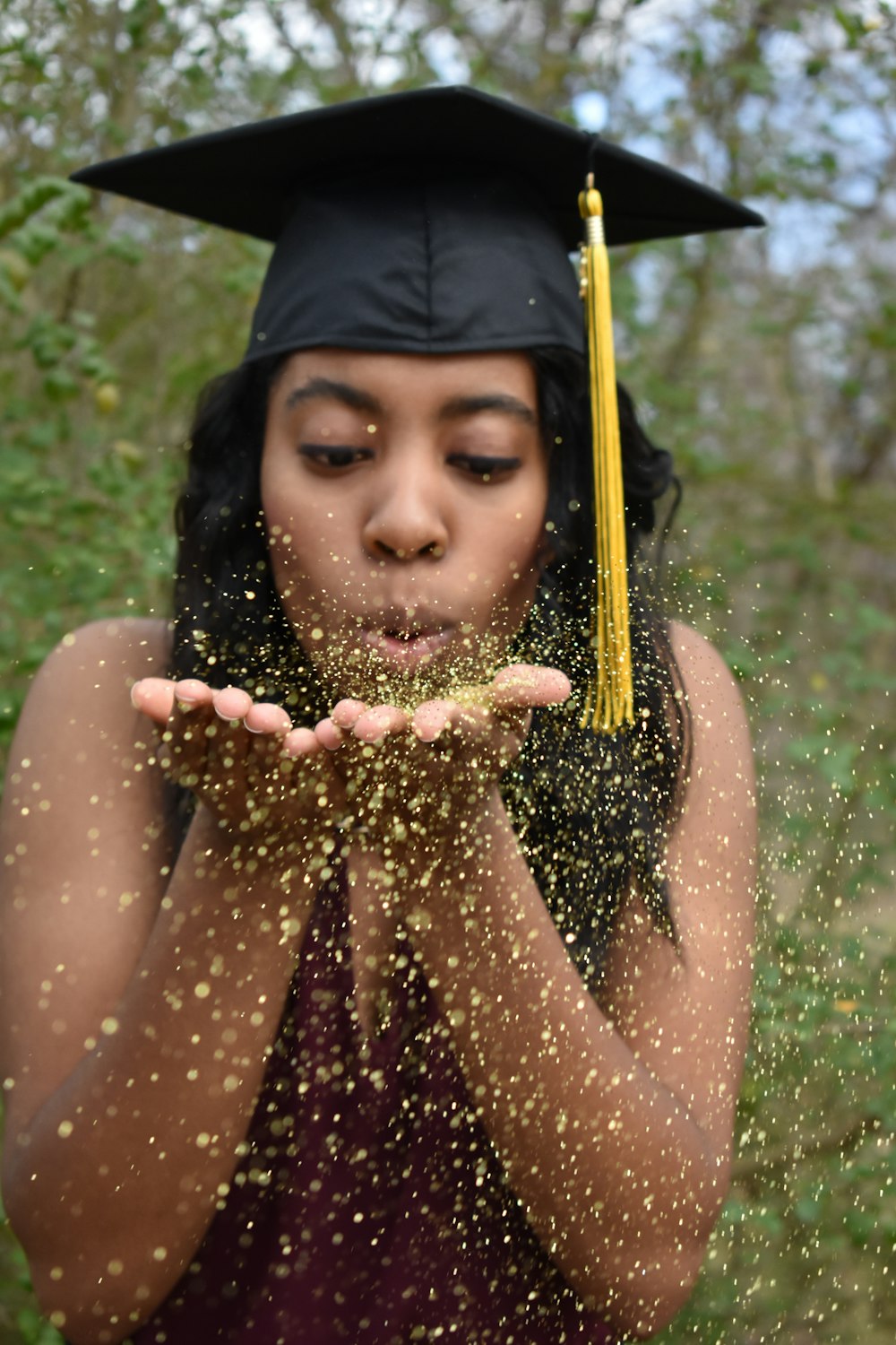 woman wearing mortarboard blowing sand