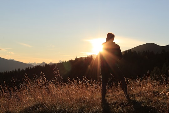 silhouette of man standing on mountain in Cermis Italy