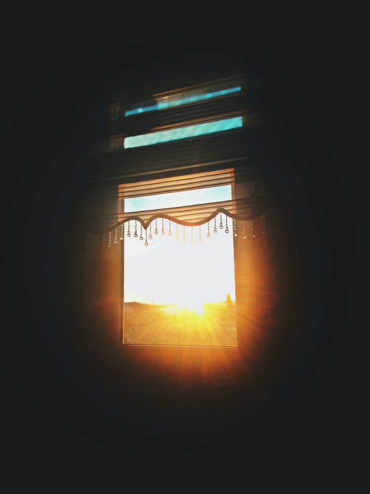 Low sun streaming through open window blinds, casting bright striped light into a room — the kind of disabling glare a solar glare assessment evaluates