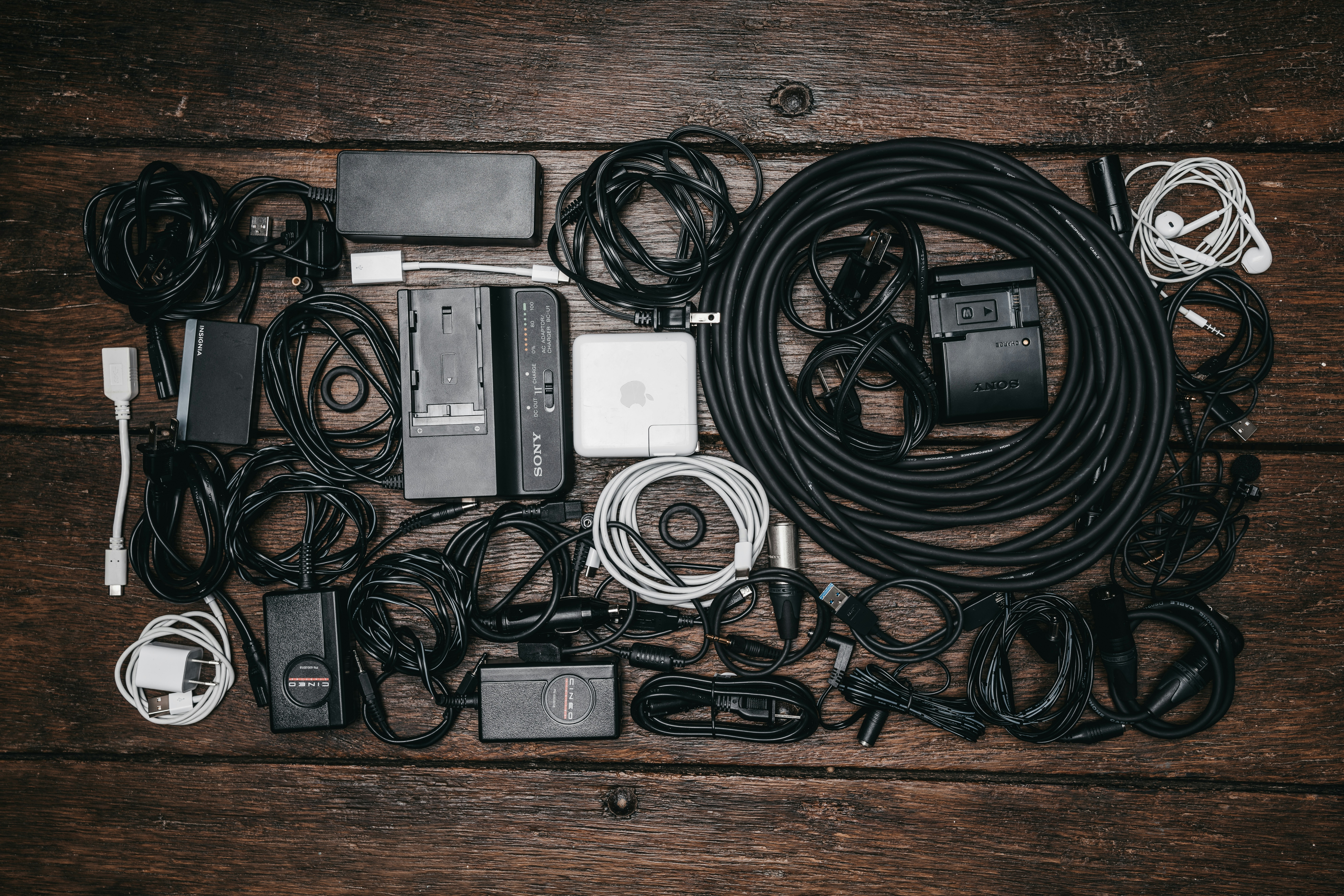 black cable lot and electronic devices on brown wooden surface