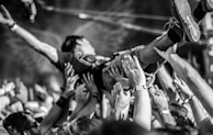 Fans crowd-surfing with wild energy at an outdoor metal festival.