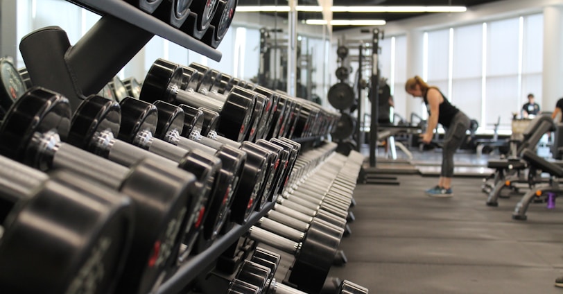 woman standing surrounded by exercise equipment