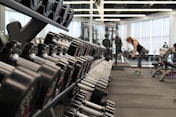 woman standing surrounded by exercise equipment