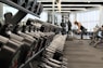 woman standing surrounded by exercise equipment