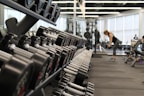 woman standing surrounded by exercise equipment