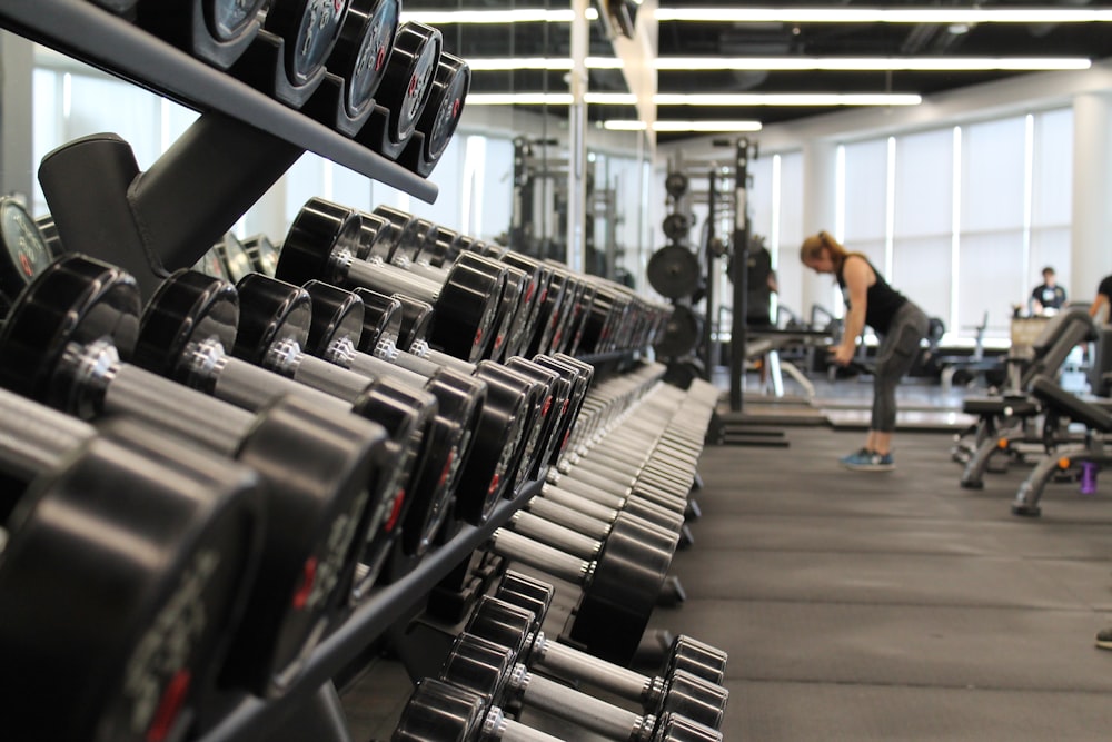 femme debout entourée d’équipements d’exercice