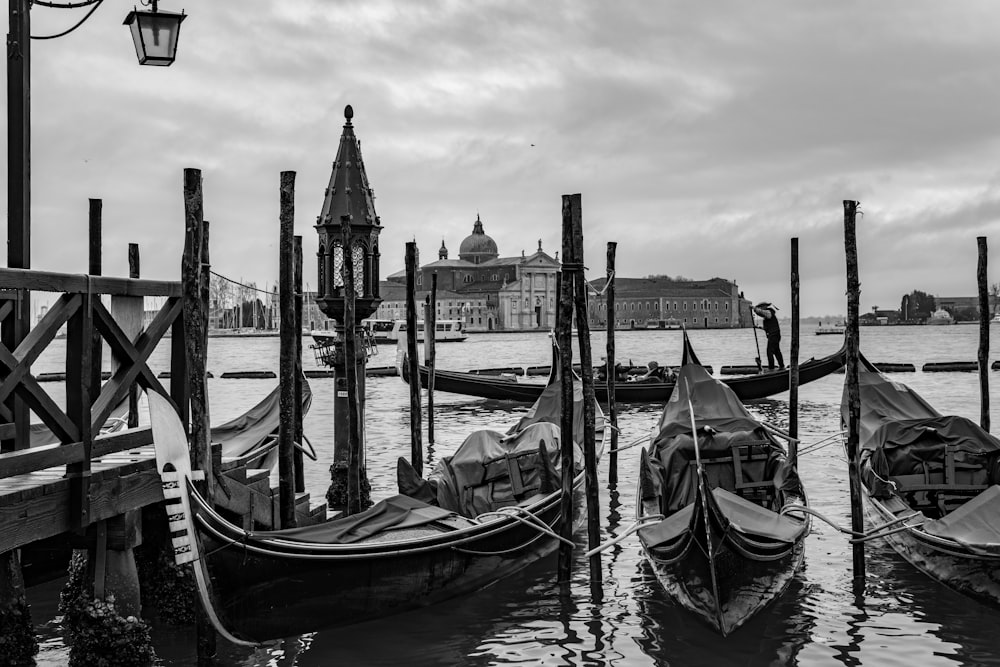 grayscale photo of boats near dock