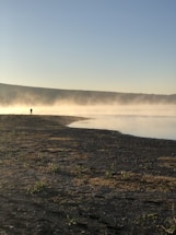 A serene lakeside view with fishing gear and jigs.