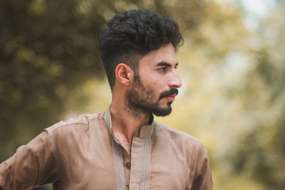 man wearing brown collared top