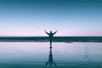 silhouette photography of person standing on body of water