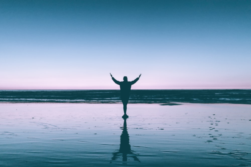 silhouette photography of person standing on body of water