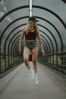 Summer outfit featuring a white tank top and black shorts, styled with chunky sneakers and a cap.
