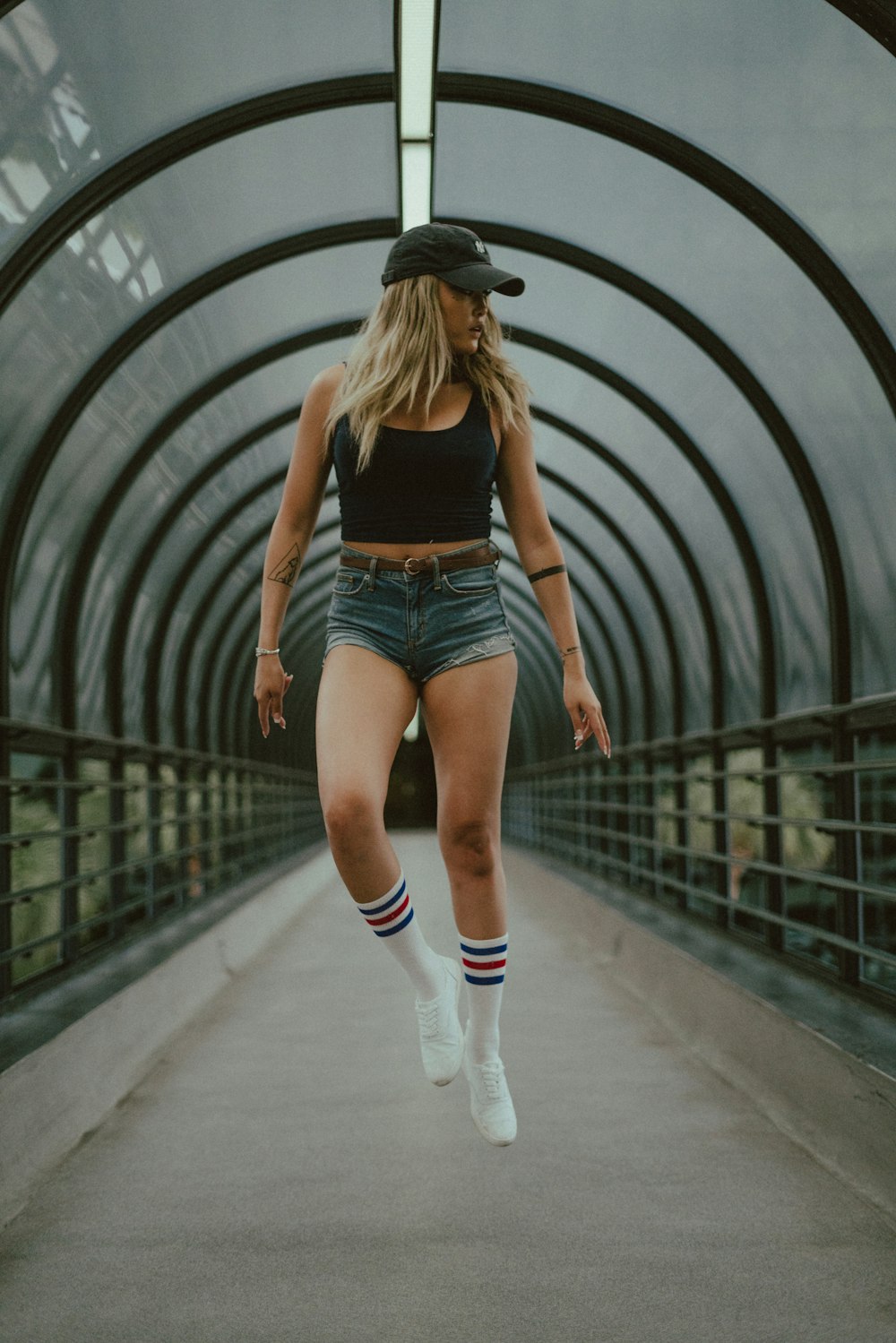 woman inside concrete walkway with black canopy during daytime