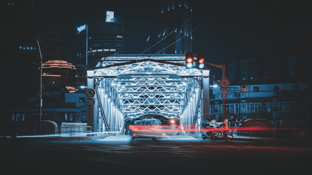 Zeitrafferaufnahme eines Fahrzeugs auf der Brücke bei Nacht