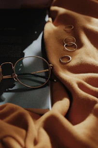 Classic round eyeglasses with thin gold rims placed on an open book.