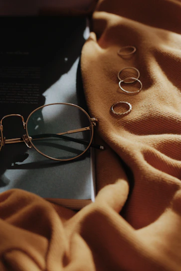 A stylish pair of round metal-rimmed glasses displayed on a vintage book.