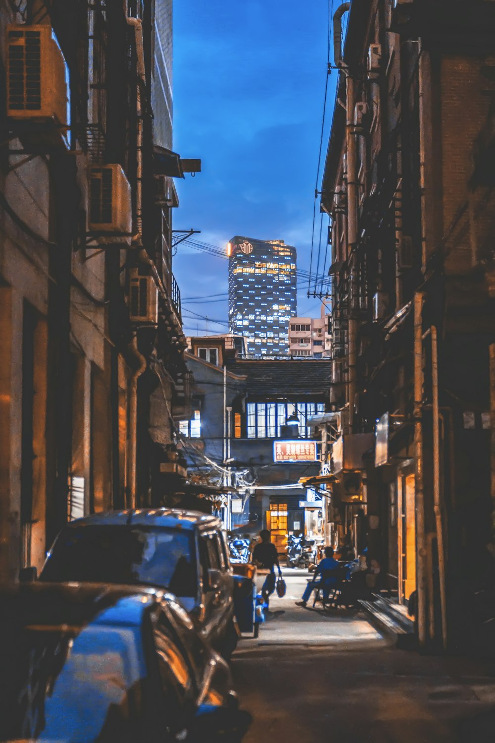 person walking between concrete building during daytime