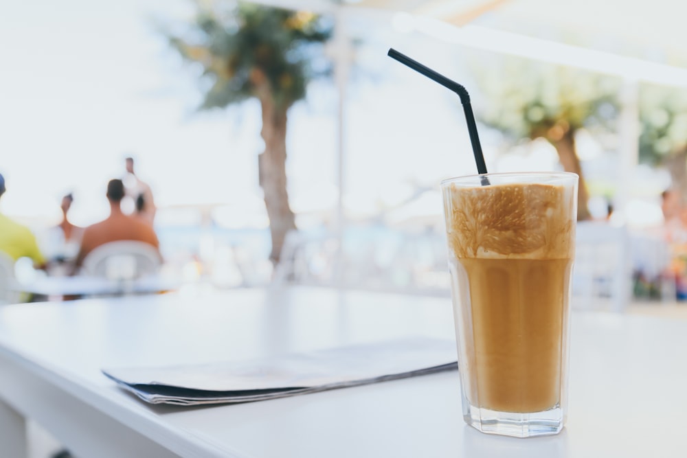 filled drinking glass with black straw