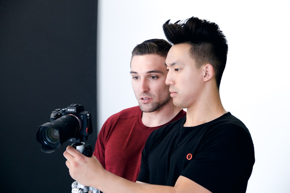 man holding black DSLR camera