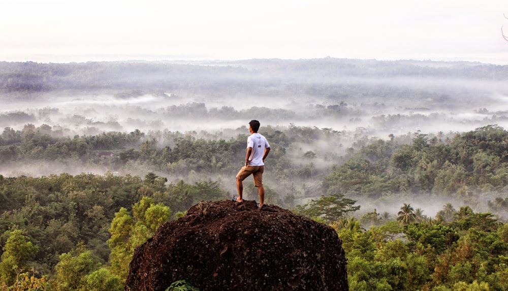 man standing on boulder