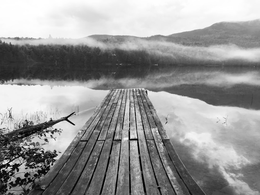 grayscale photography of dock beside body of water