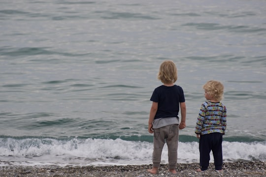 two child standing on shore in Kalamata Greece