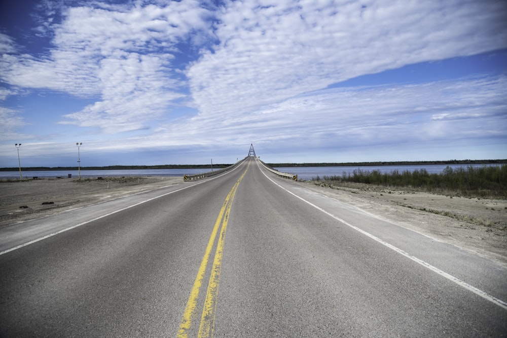 gray asphalt road under white clouds