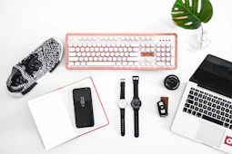 laptop computer beside analog watches on table