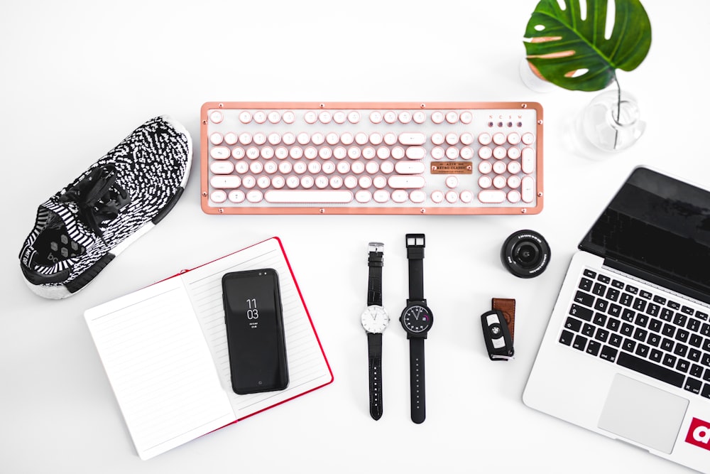 laptop computer beside analog watches on table