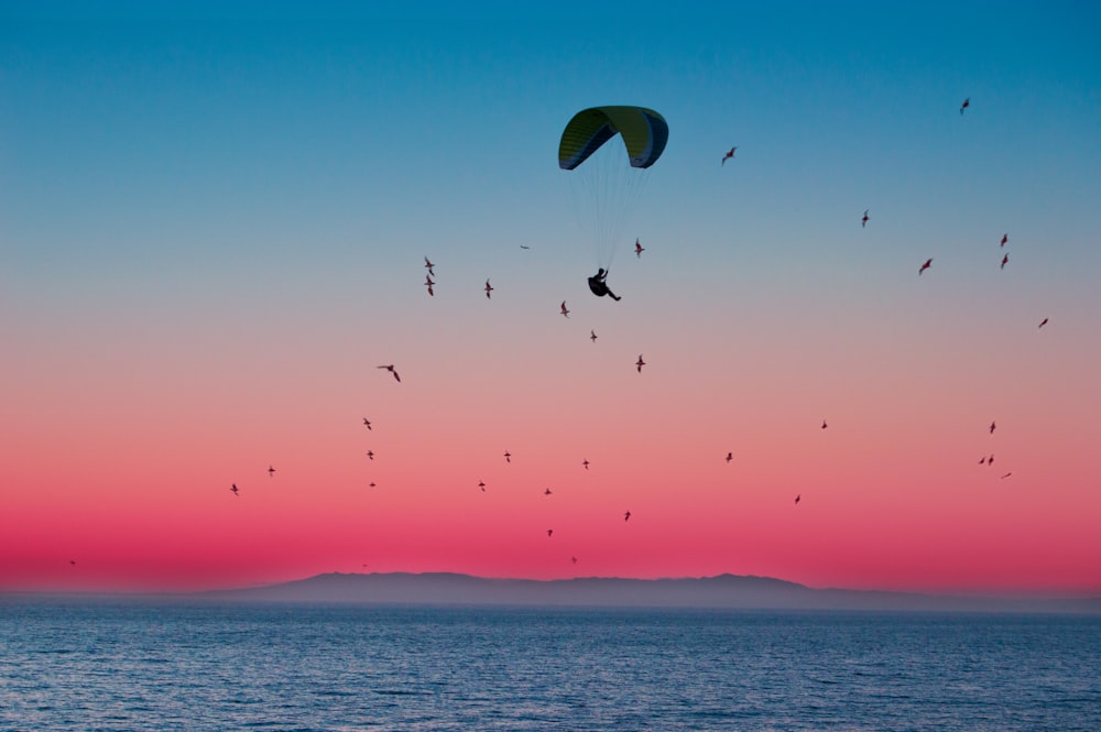 person riding parachute under sea water