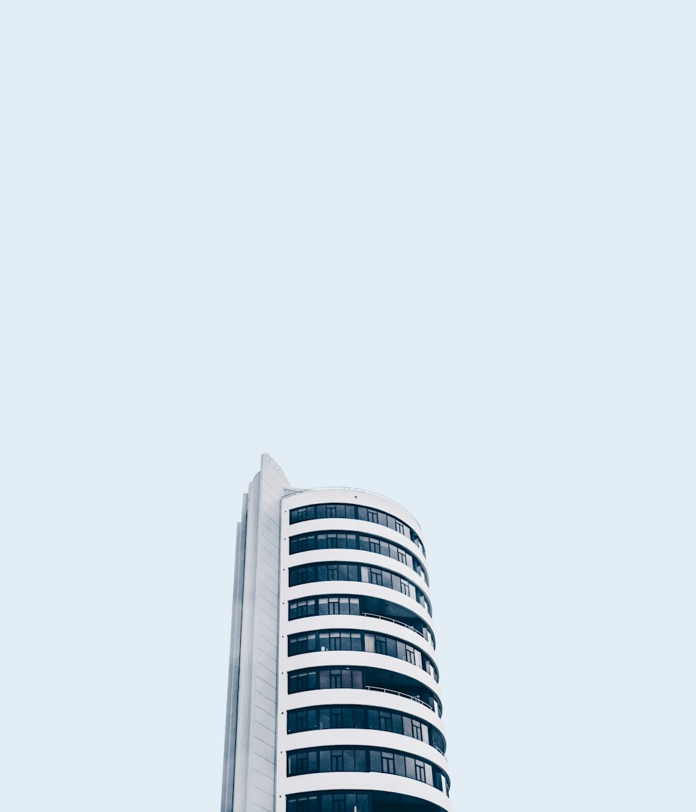Foto de ángulo bajo de un edificio blanco de gran altura bajo el cielo blanco durante el día