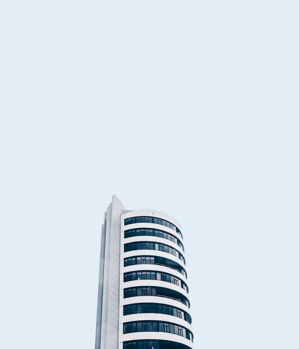 low angle photo of white high rise building under white sky at daytime