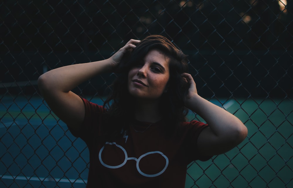 woman standing in front of cyclone fence