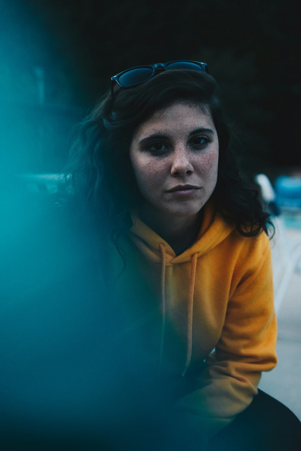 woman wearing yellow pullover hoodie sitting outdoor