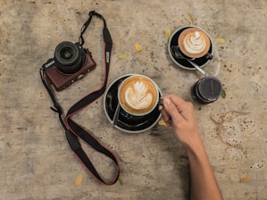 Close-up of a handcrafted wooden photo frame resting on a rustic wooden table with a warm coffee cup nearby.