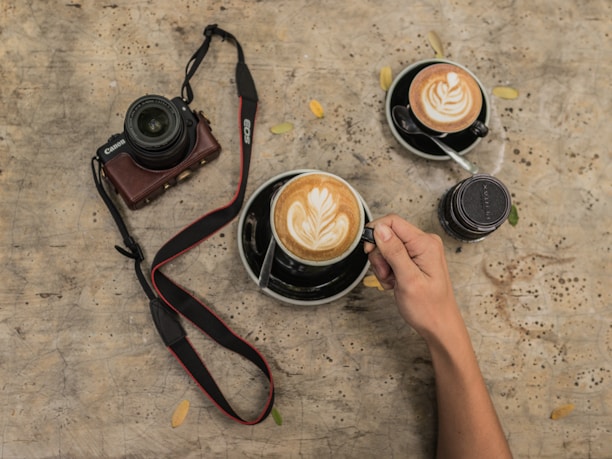 Close-up of a handcrafted wooden photo frame resting on a rustic wooden table with a warm coffee cup nearby.