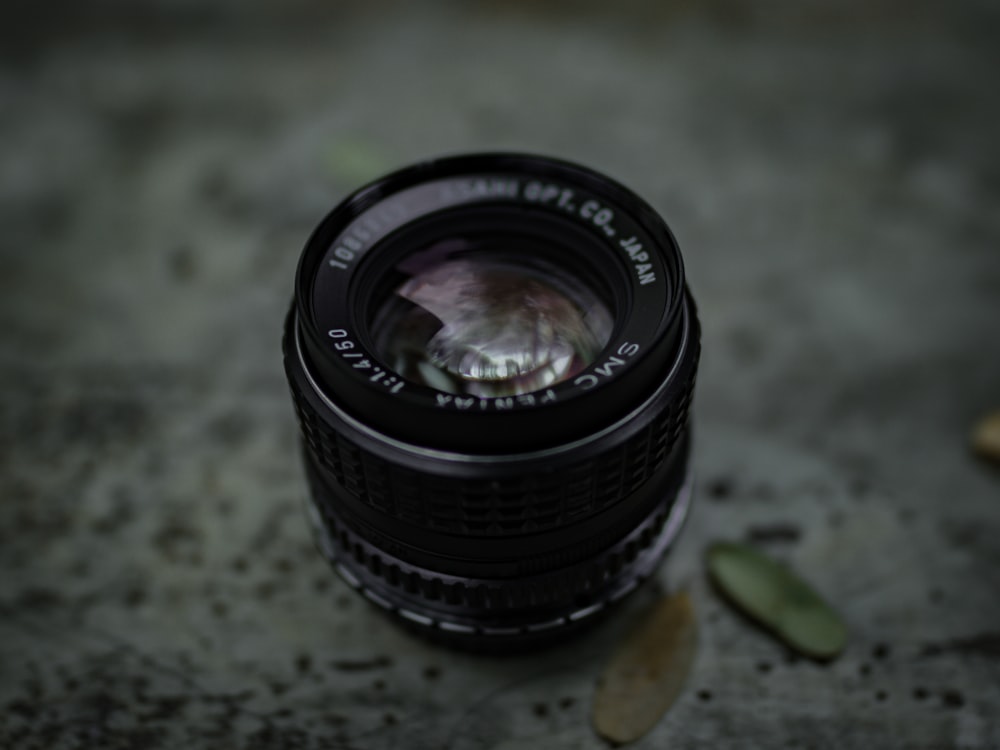 selective focus photography of black camera lens on brown surface