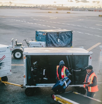 two men holding luggage on airport