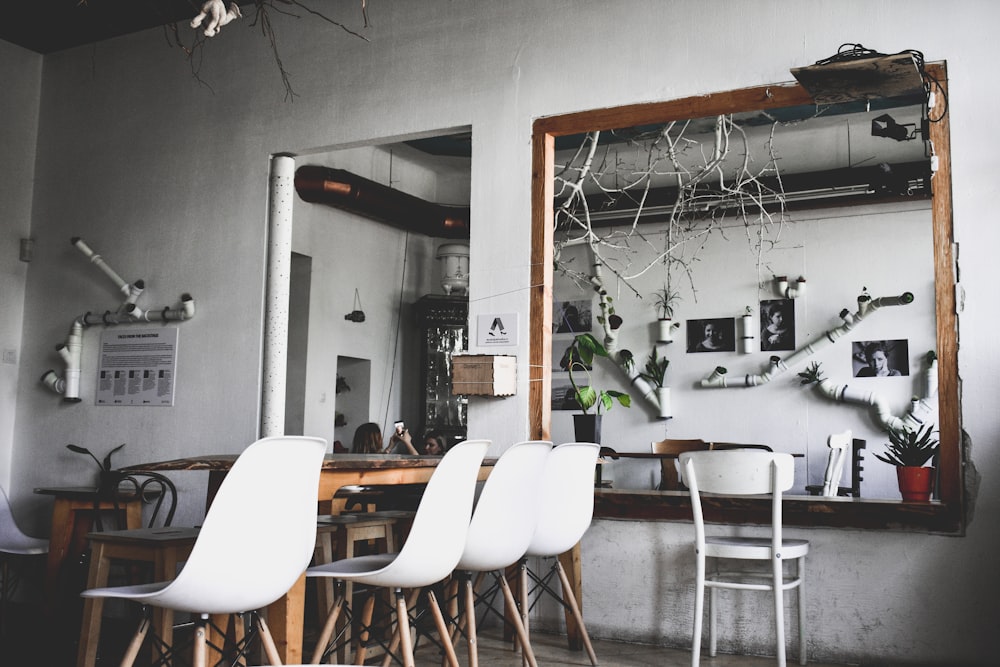 four white chairs near brown wooden table indoors