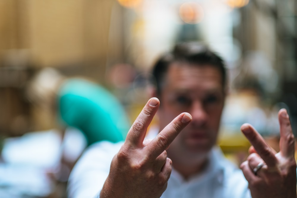 man doing peace hand signs