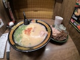 Warm bowl with steaming ramen topped with ingredients in a modern setting
