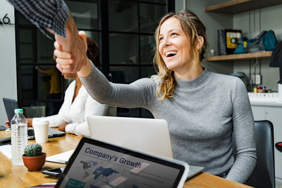 smiling woman shaking hands with another person