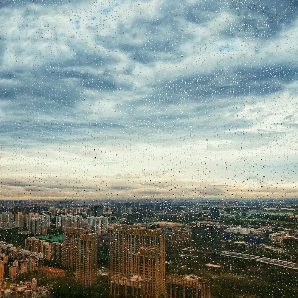 Wassertau auf Glas mit Blick auf die Stadt