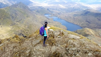 woman standing at the peak of mountain