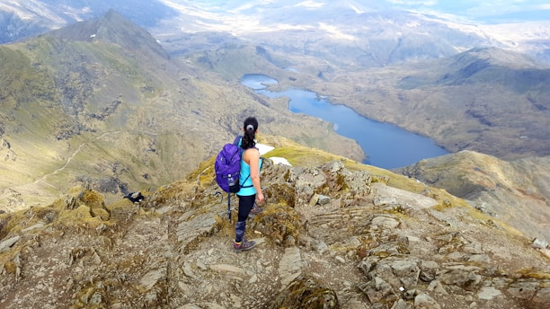 woman standing at the peak of mountain
