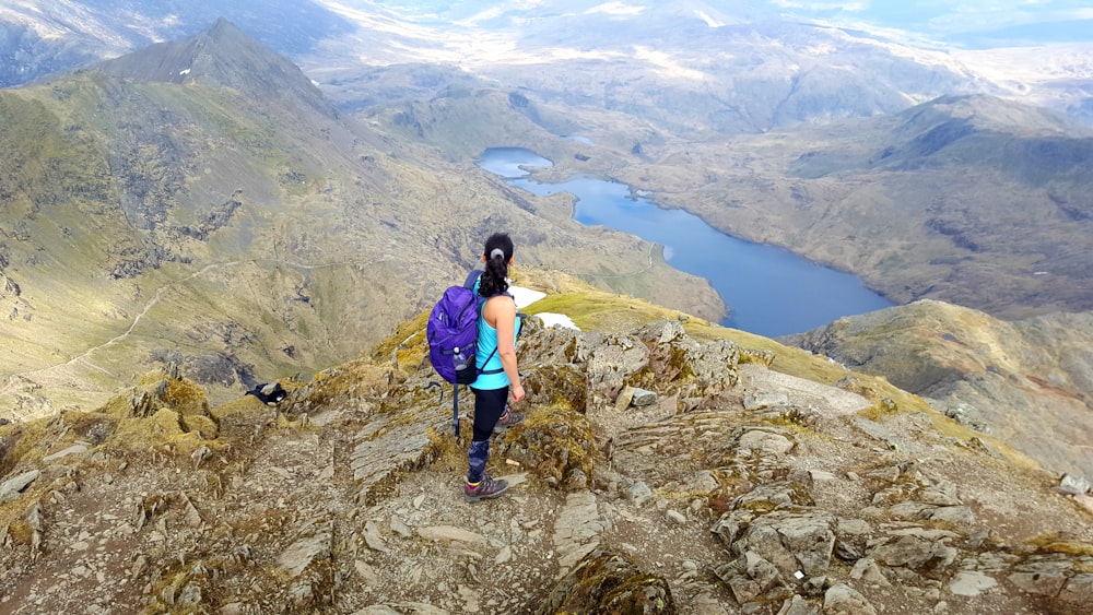 mujer de pie en la cima de la montaña