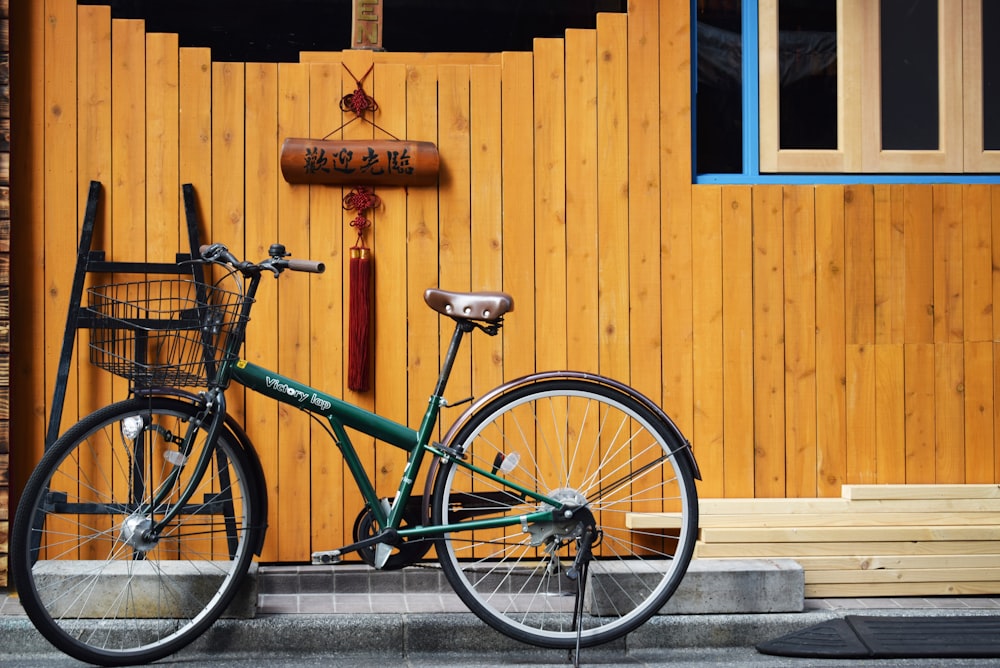 green bike beside wooden wall