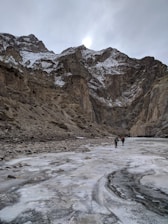 A group of hikers enjoying the sunrise over the desert landscape with snowcapped mountains.